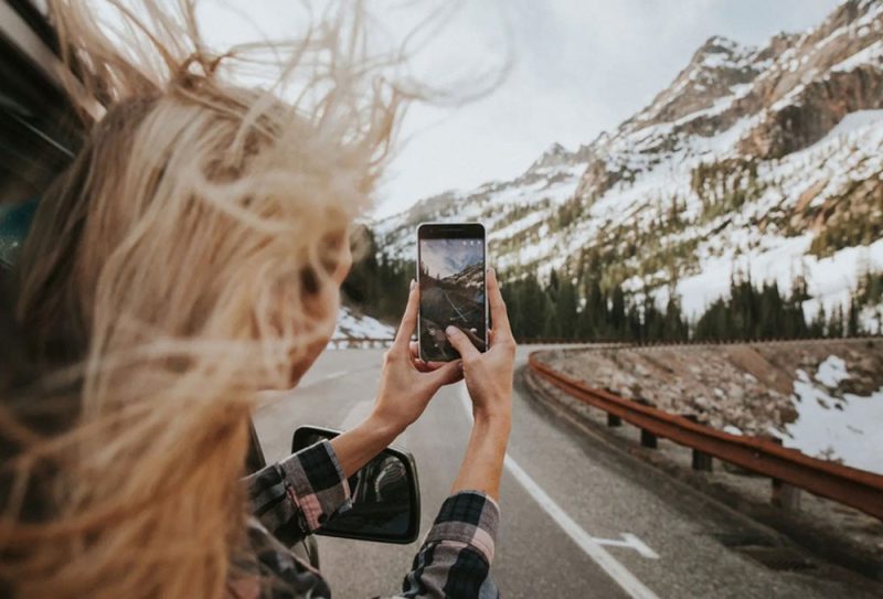 Confident female travelers posing together with backpacks and scenic mountain views, symbolizing empowerment and adventure.