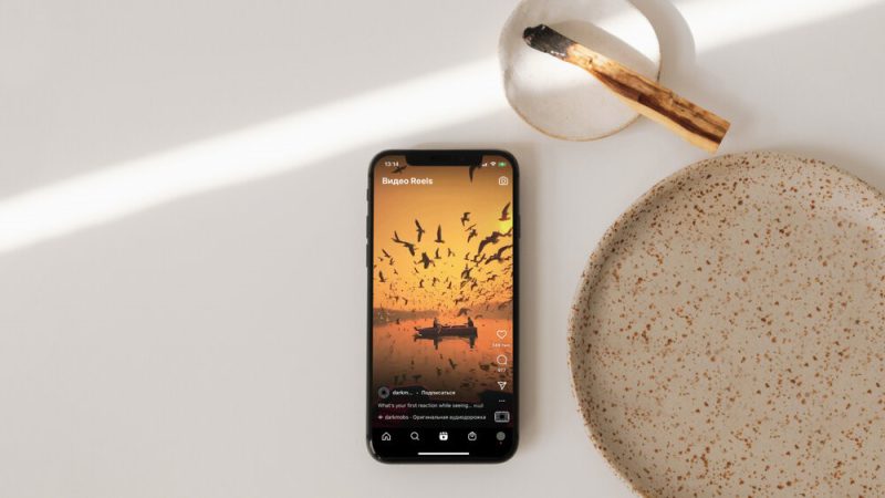 Hands navigating Instagram settings on a mobile phone, focusing on privacy options to manage or block Reels content.
